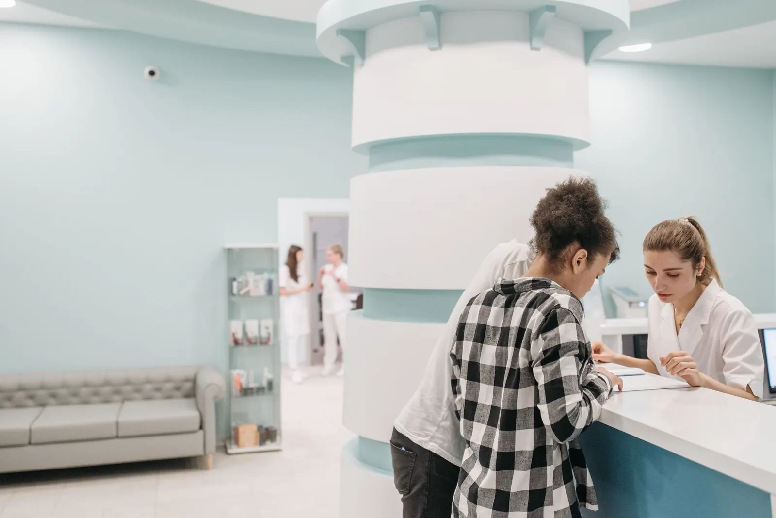 Patient being helped at a bright, modern clinic reception desk